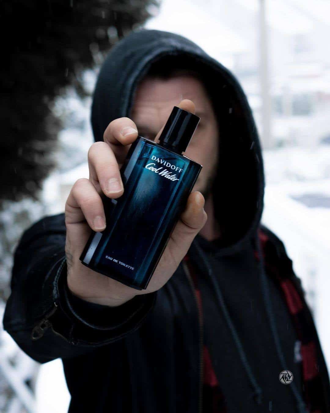 holding a bottle of davidoff cool water