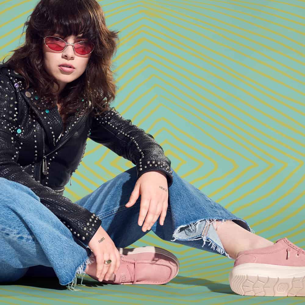 woman wearing a pair of pink heydude shoes